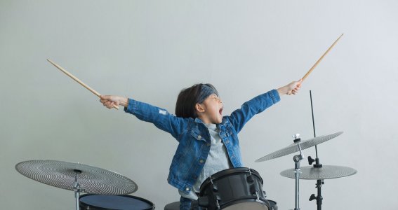 Kind streckt Drumsticks in die Luft