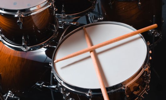 Schlagzeugkurs für Kinder in München Drumsticks liegen auf einer Trommel