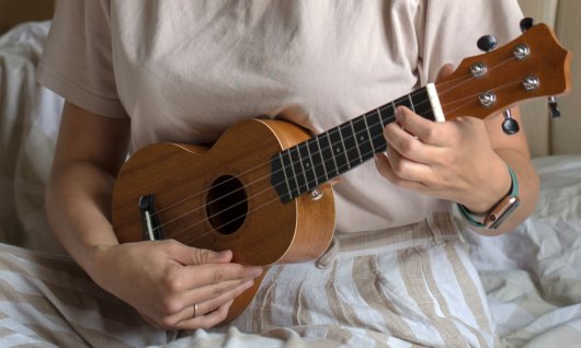 Ukulelenkus für Erwachsene Person hält Ukulele