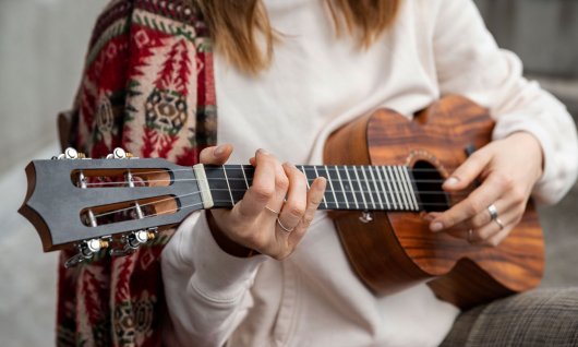 Ukulele spielen in München für Erwachsene Frau spielt Ukulele