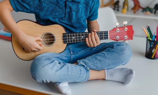 Kind spielt Ukulele