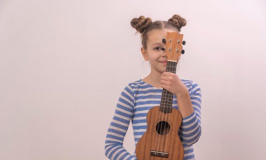 Ukulelenunterricht für Kinder in München Mädchen hält eine Ukulele