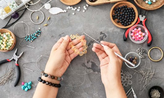 Tisch voll mit Schmuck und Frau macht eine Kette
