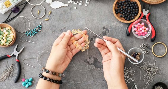 Tisch voll mit Schmuck und Frau macht eine Kette