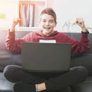 Programmieren Lernen mit Max Junge der vor einem Computer sitzt und sich freut