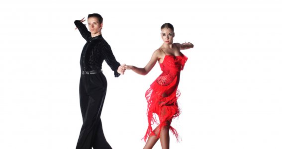 Zwei Tänzer in professionellen Kostümen stehen in einer offenen Tanzpose