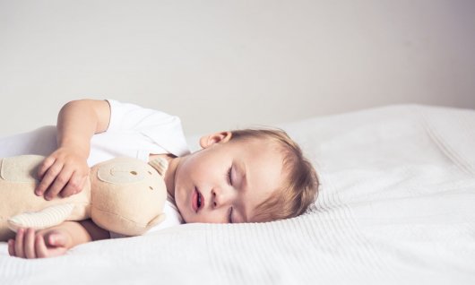 Baby schläft auf einer Matratze. 