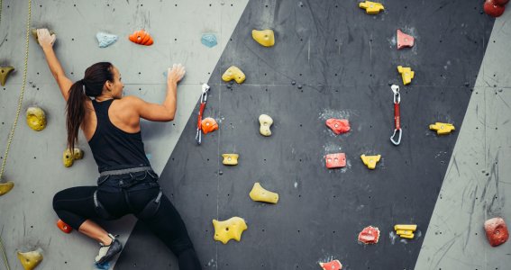 Frau klettert an Wand