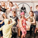 Selbstverteidigungskurs für Kinder in München Kinder zeigen ihre Muskeln vor dem Warrior Kids Logo