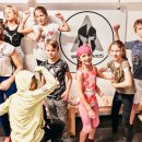 Kinder zeigen ihre Muskeln vor dem Warrior Kids Logo