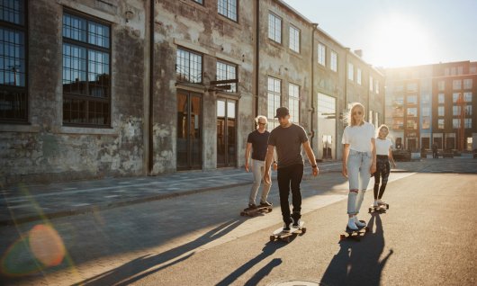 Eine Gruppe junger Leute fährt in einem heruntergekommenen Stadtteil Skateboard