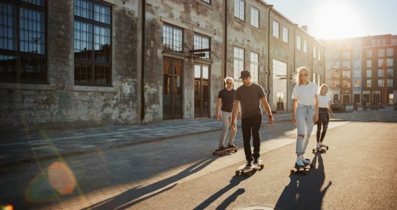 Eine Gruppe junger Leute fährt in einem heruntergekommenen Stadtteil Skateboard