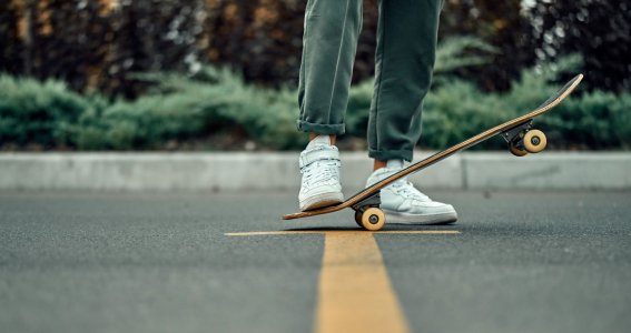 Ein Skateboard wird mit einem Fuß gehalten
