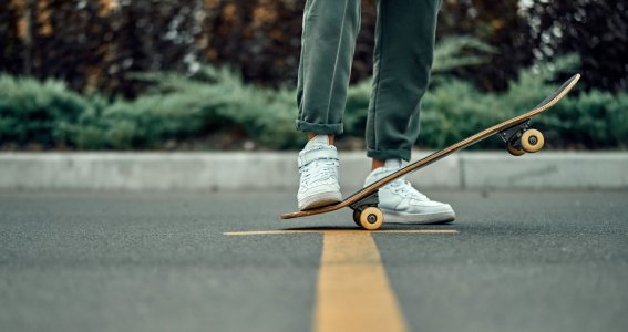 Ein Skateboard wird mit einem Fuß gehalten