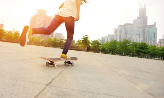 Eine junge Frau fährt Skateboard