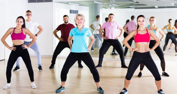 Mehrere Menschen in Sportkleidung tanzen in einem Tanzstudio Zumba Fitness