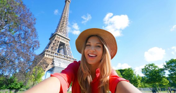 Frau macht ein Selfie vor dem Eiffelturm