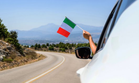 Eine italienische Flagge wird aus dem Auto gehalten