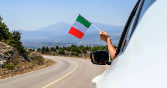 Eine italienische Flagge wird aus dem Auto gehalten