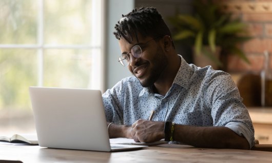 Mann sitzt vor einem Laptop