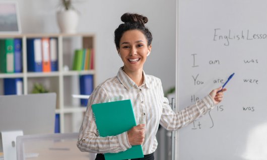 Frau zeigt mit einem Stift auf ein Whiteboard