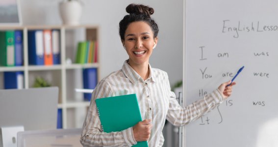 Frau zeigt mit einem Stift auf ein Whiteboard