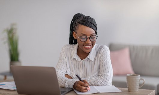 Frau schreibt auf ein Blatt Papier