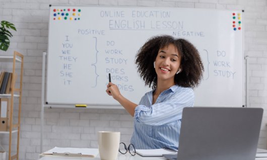Frau zeigt auf beschriftetes Whiteboard