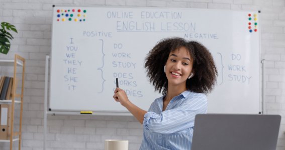 Frau zeigt auf beschriftetes Whiteboard