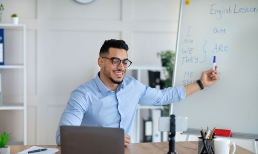 Mann sitzt am Schreibtisch und arbeitet am Laptop