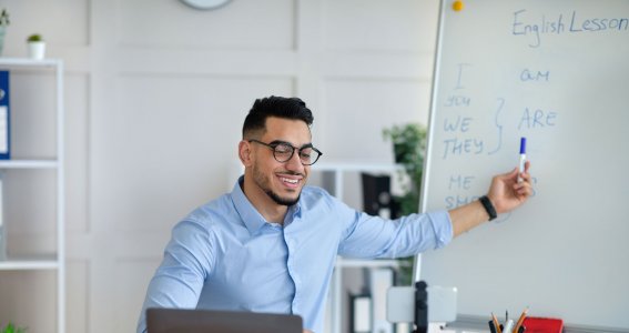 Mann sitzt am Schreibtisch und arbeitet am Laptop