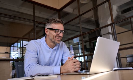 Mann lacht in den Laptop