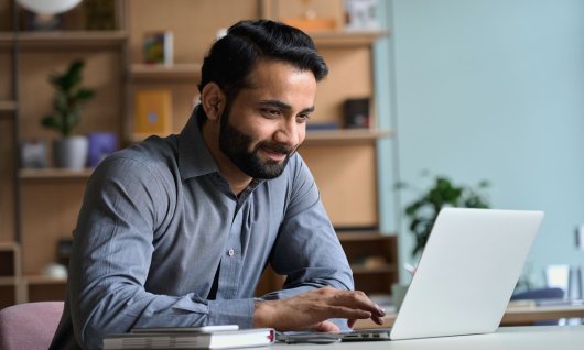 Mann tippt am Laptop