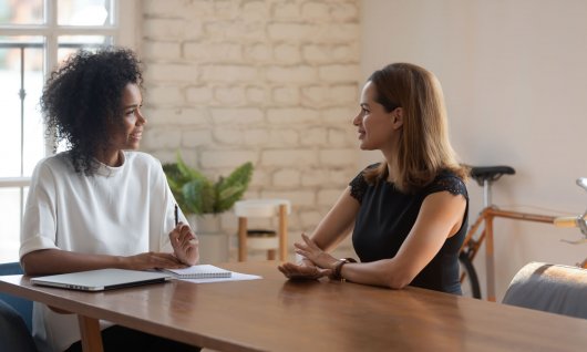 Zwei Frauen sitzen sich gegenüber