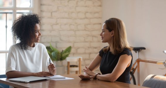 Zwei Frauen sitzen sich gegenüber