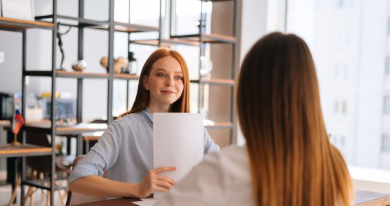 Frau hält ein Stapel Papier 