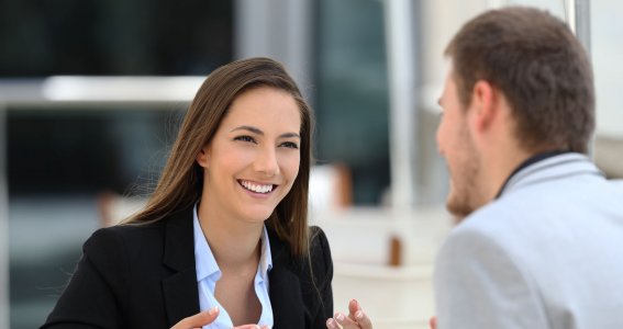 Frau und Mann unterhalten sich an einem Tisch