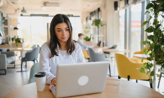 Frau schaut auf den Bildschirm eines Laptops