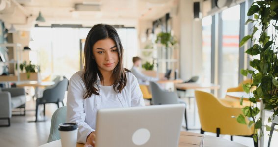 Frau schaut auf den Bildschirm eines Laptops