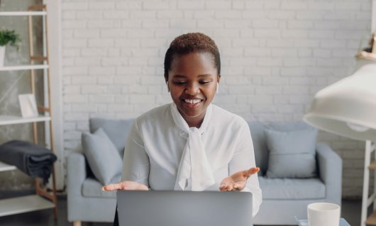 Frau sitzt und schaut auf ihren Laptop