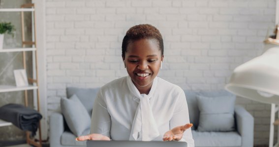 Frau sitzt und schaut auf ihren Laptop