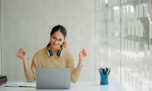 Frau schaut auf ihrem Laptop und lacht