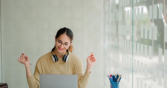 Frau schaut auf ihrem Laptop und lacht