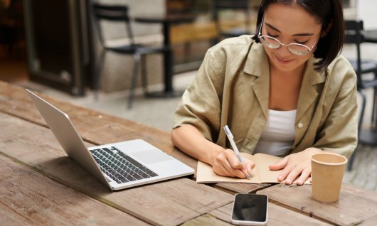 Frau schreibt Notizen auf einen Block