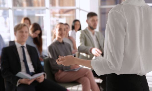 Frau redet vor einer Gruppe