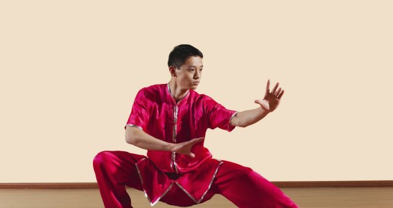 Ein Jugendlicher in Kung Fu Kleidung posiert