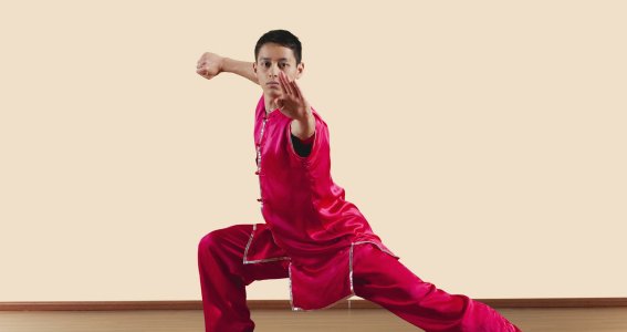 Ein Jugendlicher in chinesischer Kleidung in Kung Fu Kampfpose