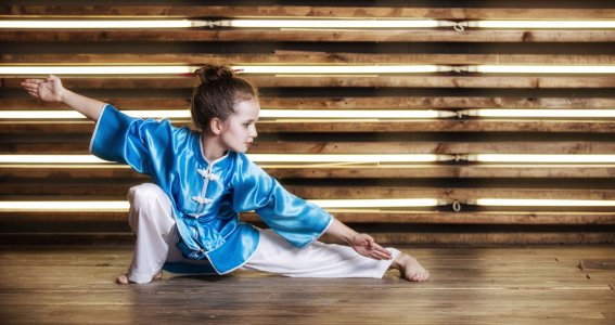 Ein junges Mädchen in Kung Fu Pose im Turnsaal