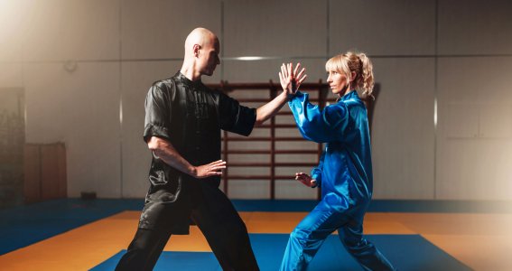 Ein Mann und eine Frau in chinesischer Kleidung trainieren Kung Fu