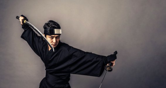 Japanischer Samurai Kämpfer mit zwei Schwertern in Kampfpose